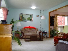 Large living room has 1 of 3 sun scopes and opens to the family sized dining room 