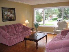 The large sunny living room has warm hardwood flooring & like the remaider of the house,its freshly painted 