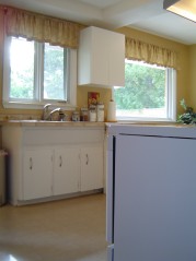 The white kitchen has 2 large sunny windows 