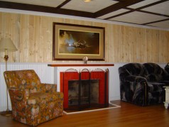Downstairs is a refurbished recreation area done in tongue and groove pine with laminate flooring & fireplace 